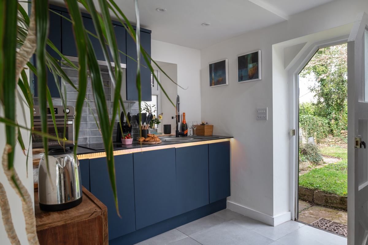 Navy kitchen with the garden door open, Fairy Cottage at Lea Hall