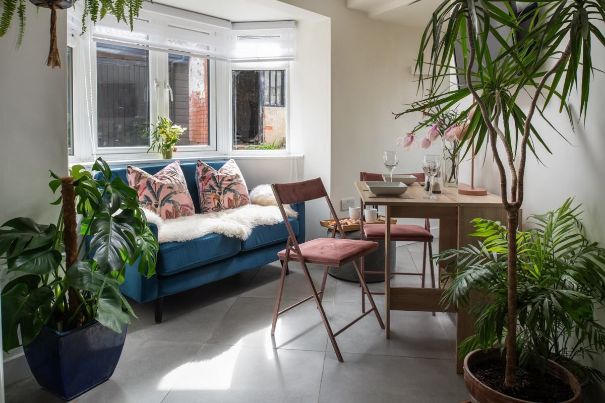 Teal velvet sofa and plants in the sitting room, Fairy Cottage at Lea Hall
